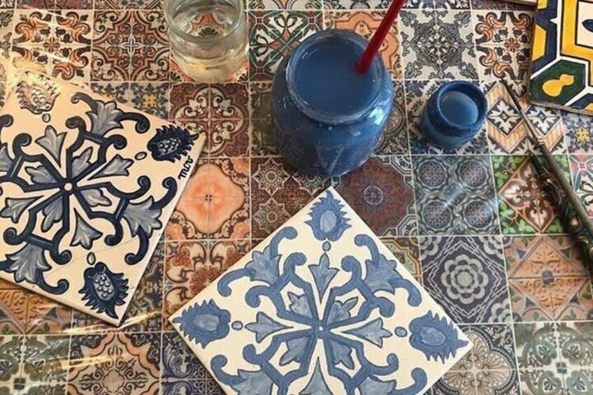 A tiled floor with intricate patterns and a blue drink with a straw. 2