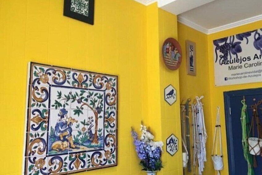 A yellow wall with a decorative tile, a framed picture, and a sign. 3
