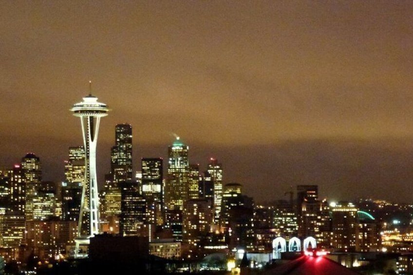 A city skyline at night with the Space Needle and illuminated buildings. 3
