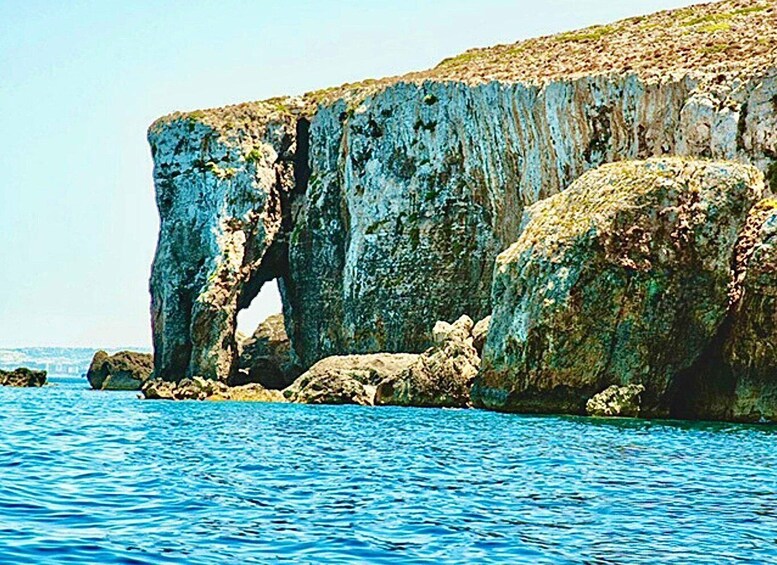 A coastal cliff with a natural arch formation. 1