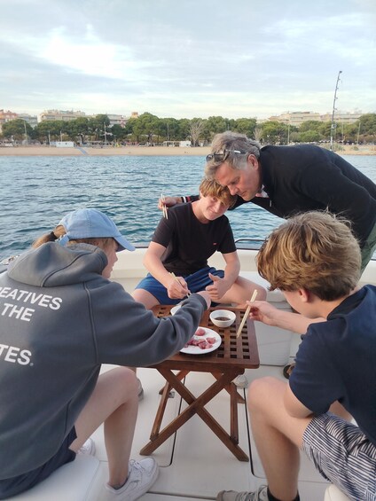 A group of people dining on a boat with a view of the sea and buildings in the background. 5