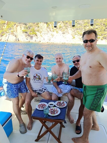 A group of people on a boat with a table of food and drinks. 3