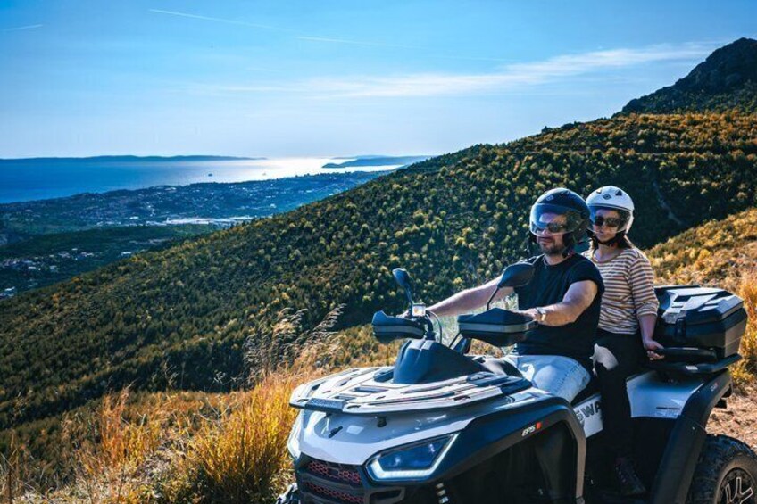A person on a quad bike with a scenic view of a coastal landscape. 1