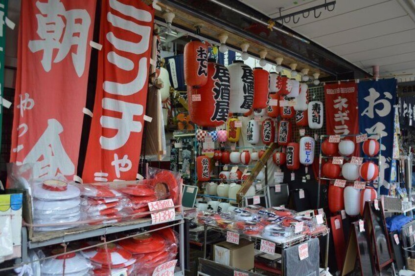 A store with red and white signage, various packaged goods, and hanging lanterns. 2