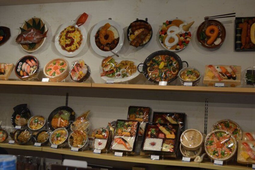 A variety of Japanese dishes displayed on shelves, each labeled with a number. 5