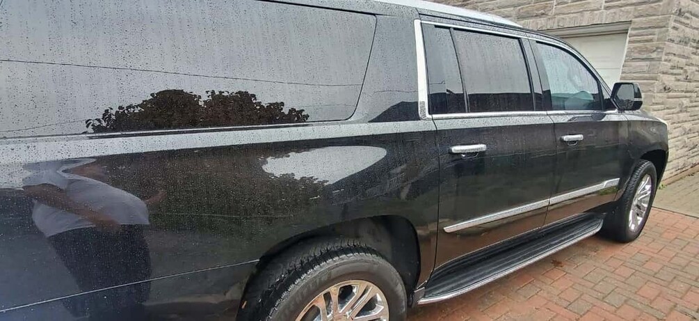 A black SUV parked on a brick pavement. 4