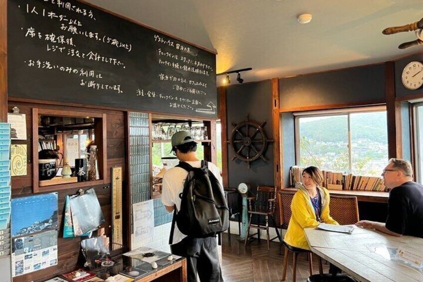 A cafe with a menu board, wooden interior, and a view of the outdoors. 3