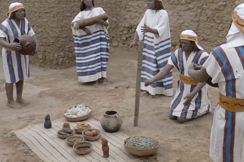 People in striped robes with a pottery wheel and various bowls and tools on the ground. 5