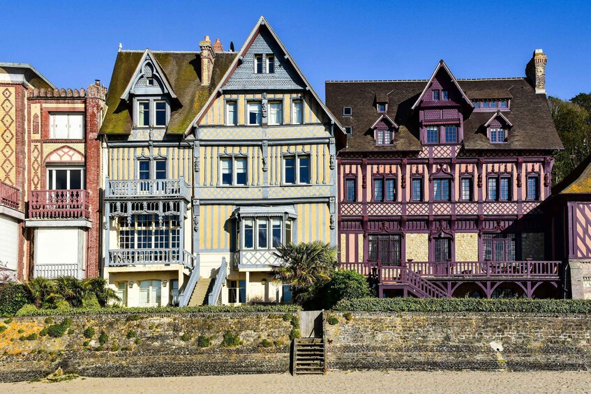 A row of colorful half-timbered houses along a coastal promenade. 3