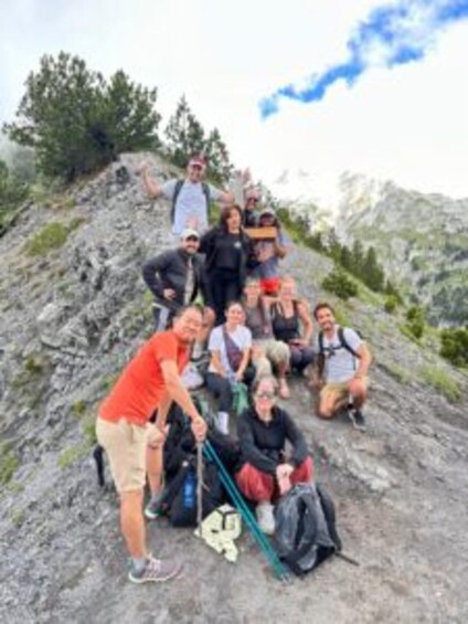A group of hikers on a rocky mountain trail with backpacks and hiking poles. 1