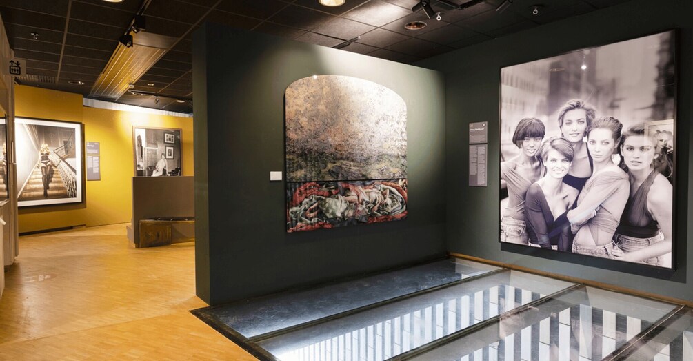 An art gallery with a large abstract painting and a black-and-white photograph on display. 2