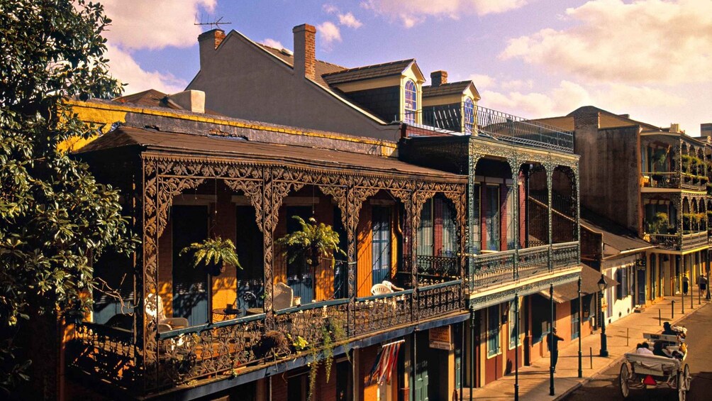 A historic building with ornate ironwork balconies and a street scene with a horse-drawn carriage. 4
