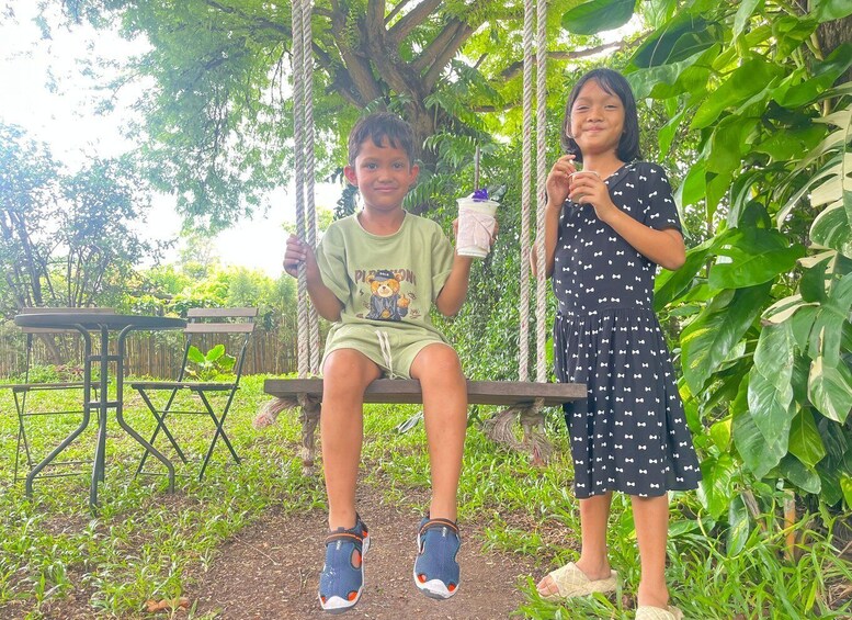 Two people on a swing in a lush garden with a table and chairs in the background. 5