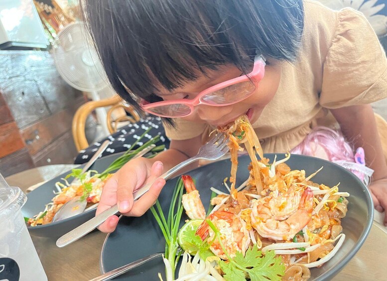 A person eating a dish with shrimp and noodles. 1