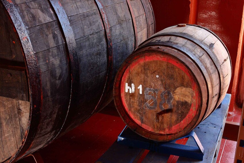Two wooden barrels with visible numbers and a red background. 2