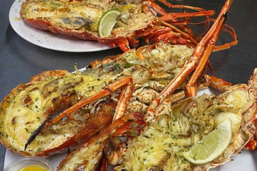 A plate of cooked lobsters garnished with herbs and lime. 5