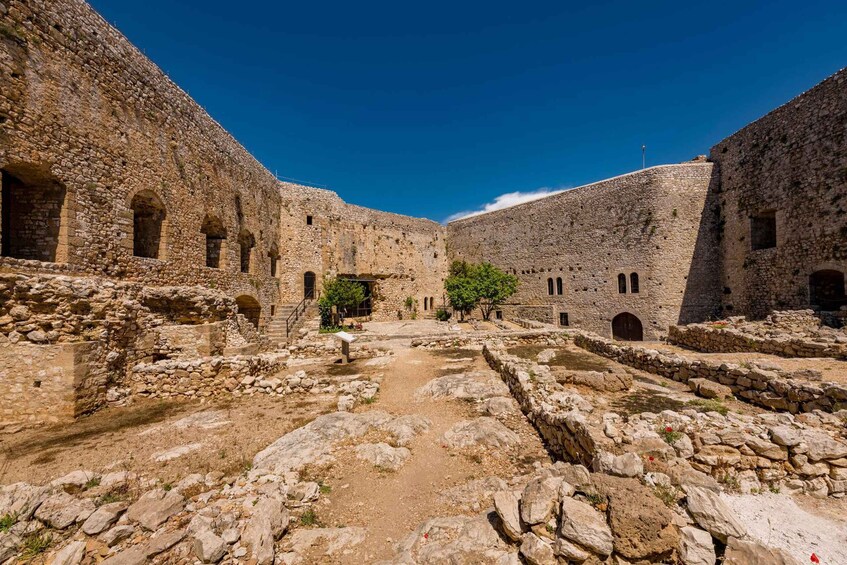 An ancient stone courtyard with arches and a central pathway. 2