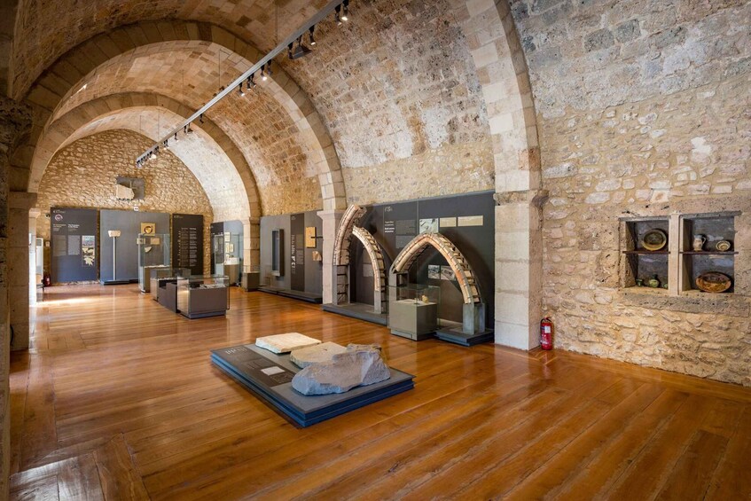 An indoor museum with stone walls, wooden floors, and exhibits. 3