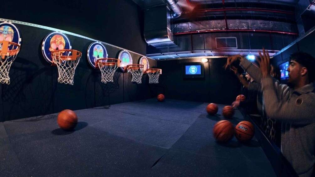 A basketball court with multiple hoops and basketballs. 4