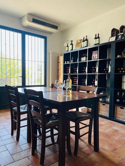 A dining area with a table, chairs, and a wine rack filled with bottles. 3