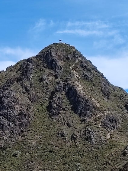 A rugged mountain with a peak, rocky terrain, and sparse vegetation. 3