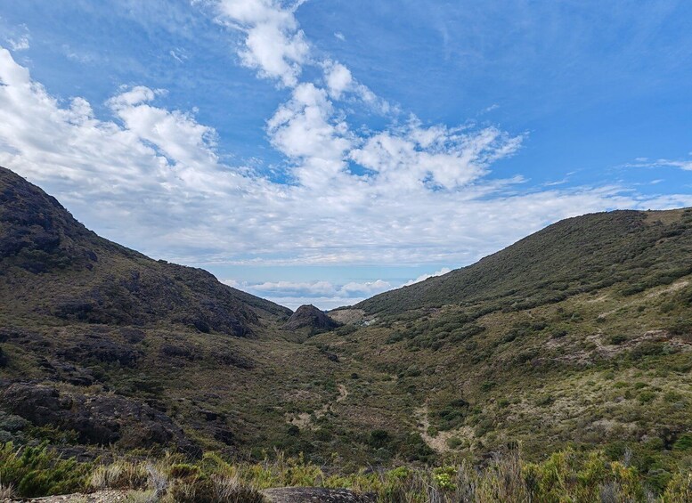 A mountainous landscape with a clear sky and scattered clouds. 2