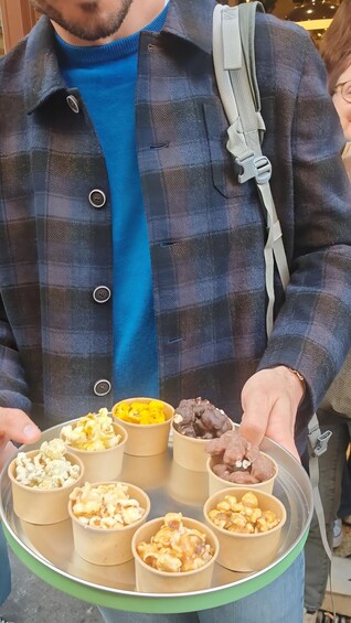A person holding a tray with various food items. 4
