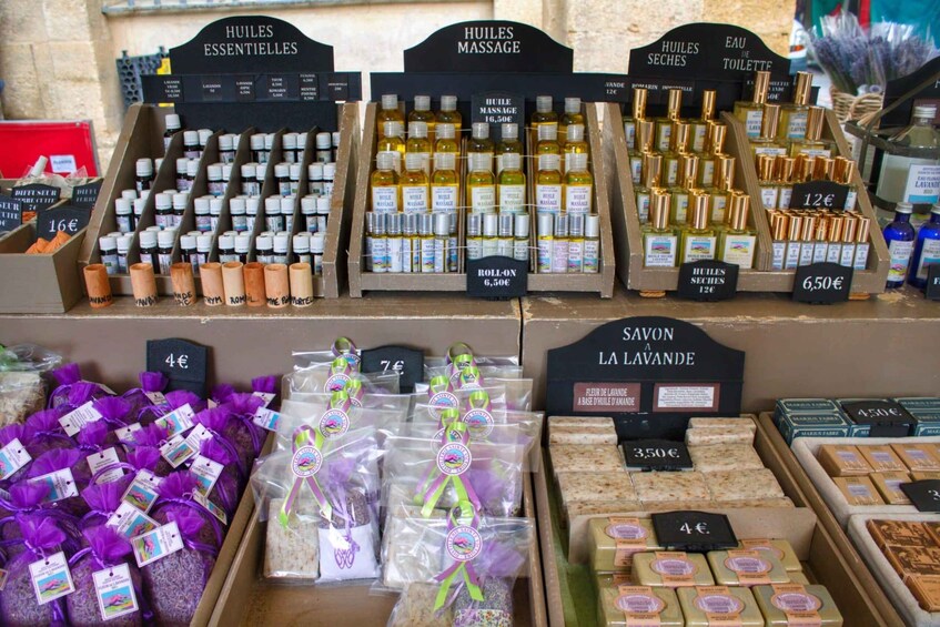 A variety of essential oils and soaps on display with price tags. 2