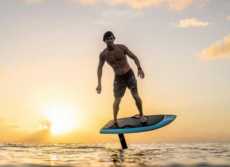A person surfing on a board with the sun setting in the background. 2