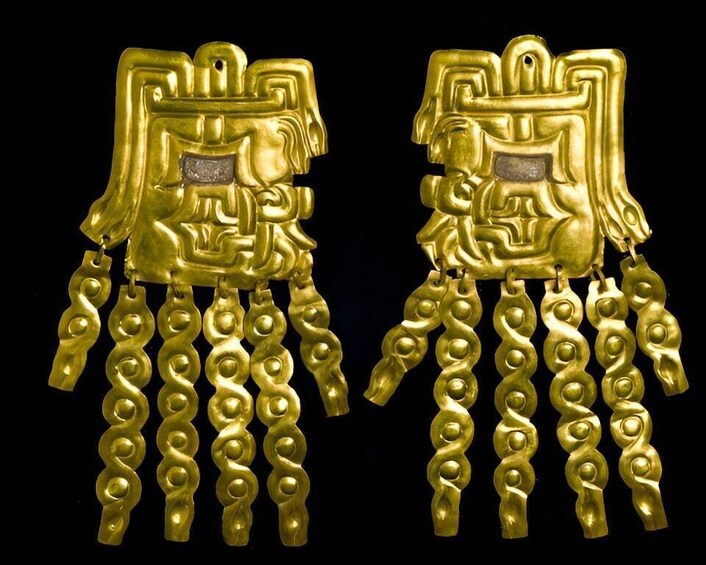 A pair of golden jewelry pieces with intricate designs and dangling elements. 4