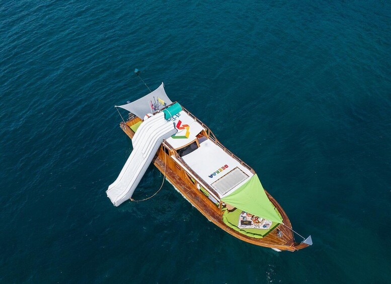 A small boat with a white canopy and a green deck, floating on a body of water. 1