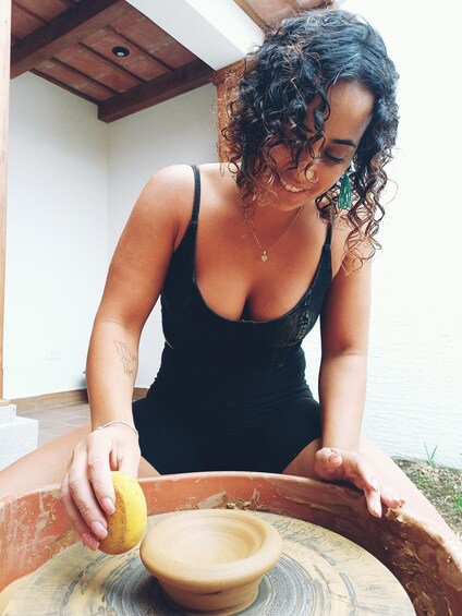 A person in a black dress using a wooden bowl. 3