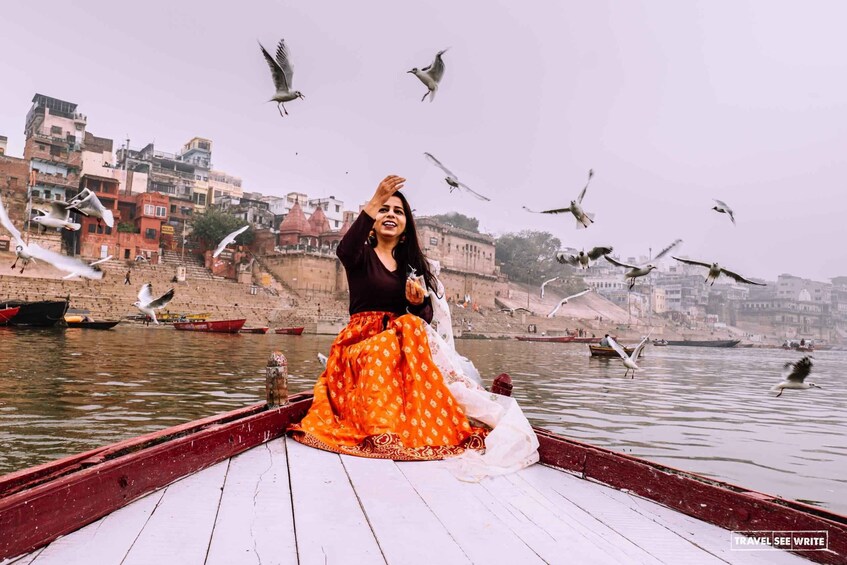 A person on a boat with a cityscape in the background. 4