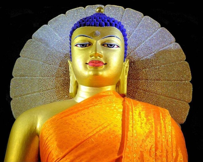A golden statue with a blue headpiece and an orange robe. 2