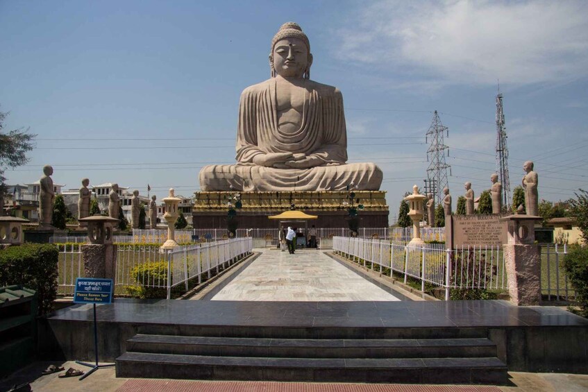 A large Buddha statue in a temple complex with a clear sky. 5