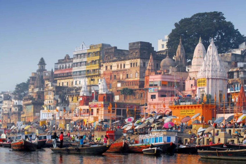 A riverside cityscape with boats, buildings, and temples. 1