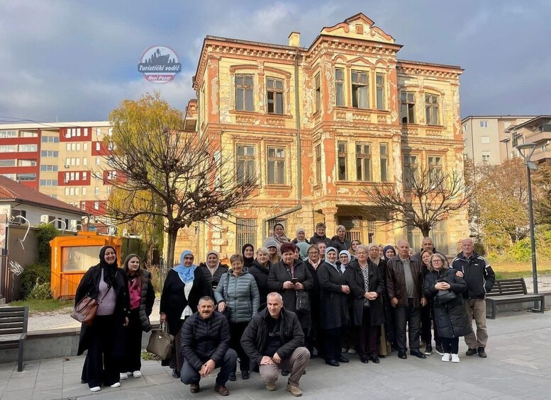 A group of people posing in front of a historic building with ornate architecture. 4
