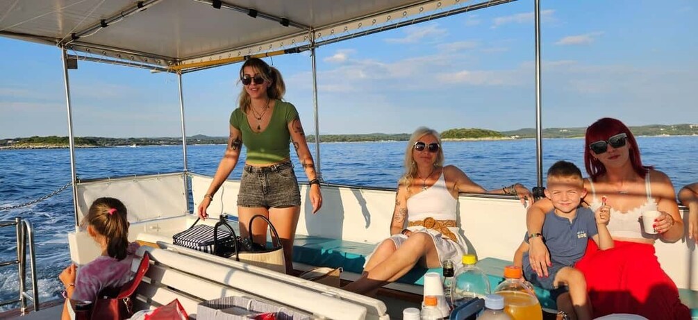 A group of people on a boat with a body of water and distant land in the background. 3