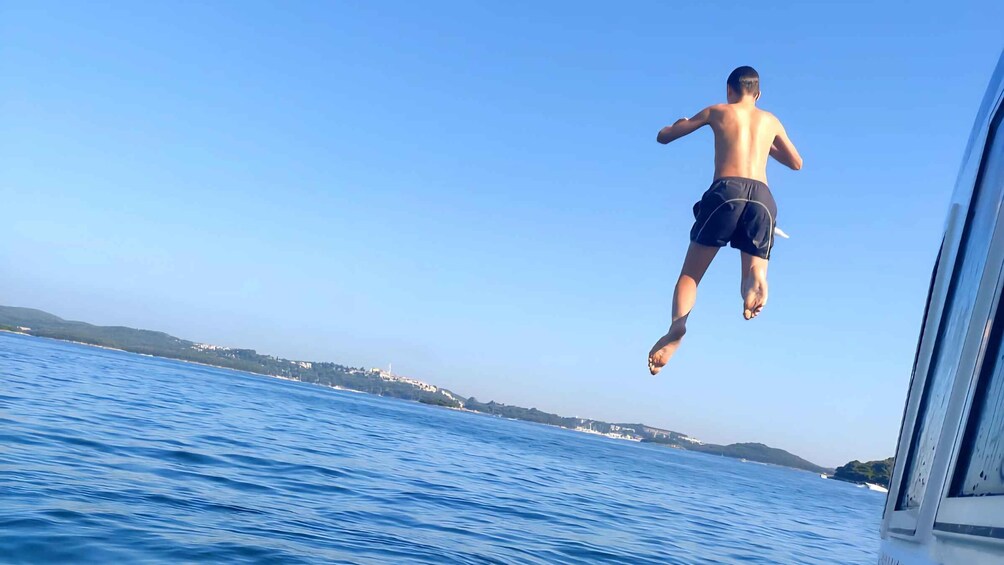 A person jumping off a boat into the sea. 1