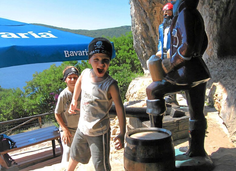 A child in a pirate-themed costume near a statue of a pirate. 5
