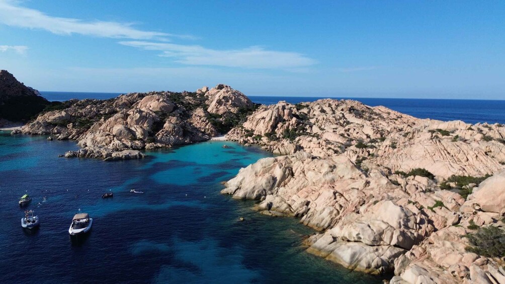 A coastal landscape with rocky outcrops and clear blue waters. 5