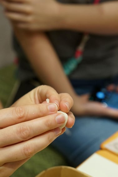 A close-up of a hand holding a small object. 4