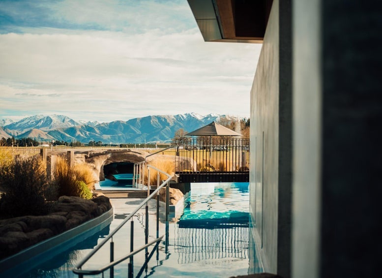 A swimming pool with a view of mountains and a bridge. 1