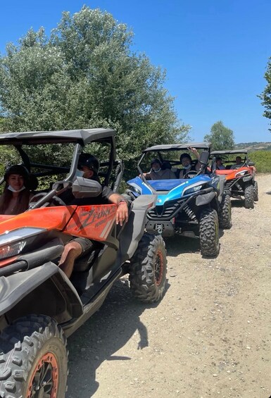 Four off-road vehicles parked on a gravel path with trees in the background. 4