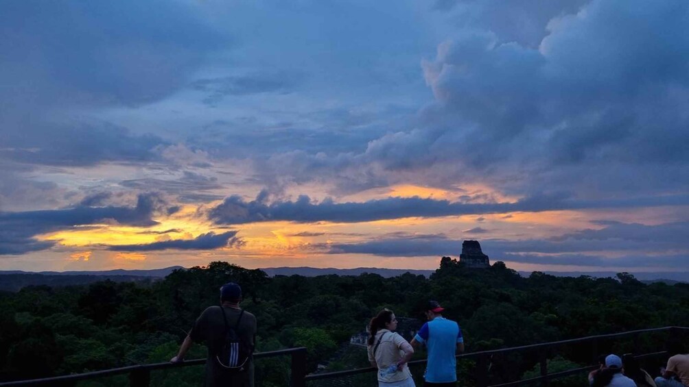 A sunset over a mountainous landscape with a prominent pyramid-like structure. 3