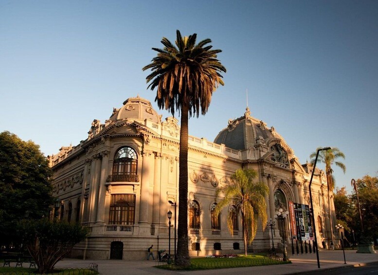 A classical building with a dome and columns, surrounded by palm trees and a clear sky. 3