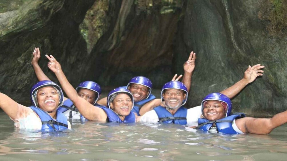 A group of people in blue helmets and life vests in a cave. 2