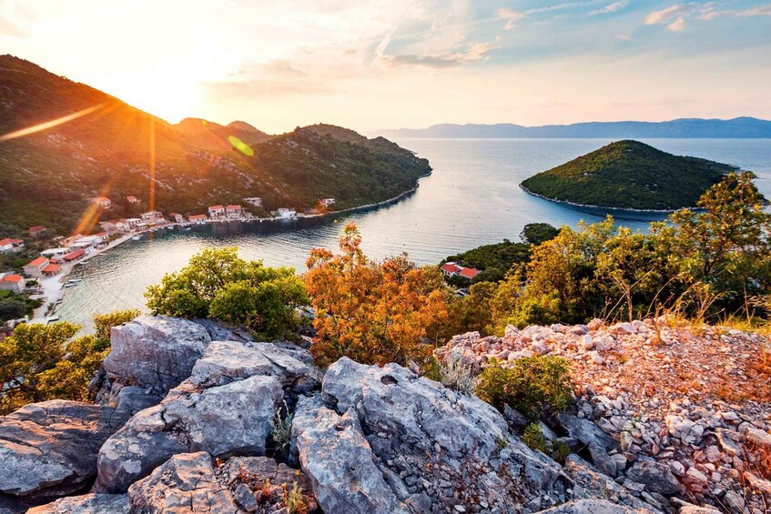 A coastal landscape with rocky outcrops, a bay, and a small island. 5