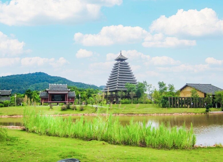 A traditional pagoda, a pond, and a forested hill in the background. 3