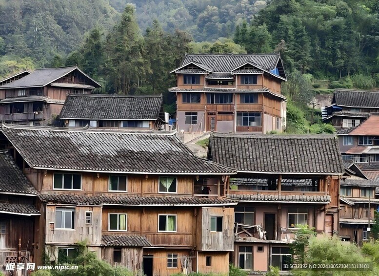 Traditional wooden buildings with steeply pitched roofs, surrounded by lush greenery and hills. 1